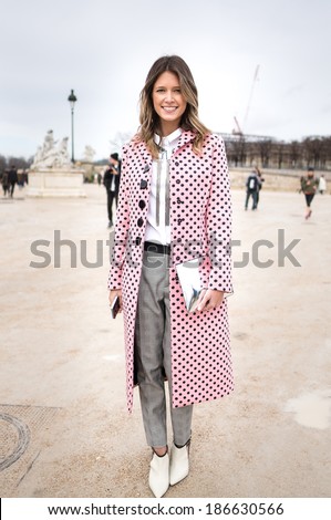 PARIS - MARCH 1, 2014: Stylish European woman with pink trench coat with black spots in the Tuileries Garden. Paris is one of the capitals of fashion in the world.