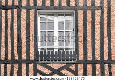 Closed window of timber frame building with red brick texture wall in Beuvron en Auge, Nomandy, France