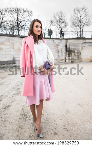 PARIS - MARCH 1, 2014: Stylish European woman with pink coat and pink skirt in the Tuileries Garden. Paris is one of the capitals of fashion in the world.