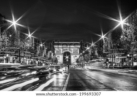 Black and White Paris: Evening traffic on Champs-Elysees in front of Arc de Triomphe (Paris, France) at Christmas Time
