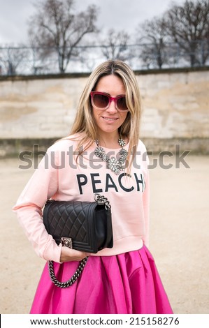 PARIS - MARCH 1, 2014: Stylish European woman with sunglasses and pink skirt in the Tuileries Garden. Paris is one of the capitals of fashion in the world.