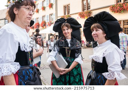 EGUISHEIM, FRANCE - AUGUST 30, 2014: Women in Alsatian traditional costume during the Wine festival.