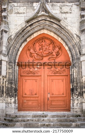 Old red door of a church in Orleans, France