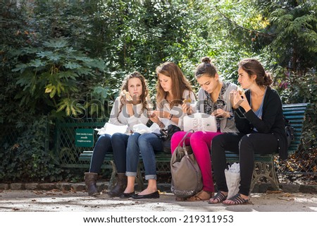 PARIS, FRANCE - SEPTEMBER 20, 2014: Female students lunch in a garden. Paris is one of the best student cities in the world.