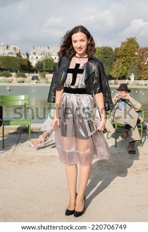 PARIS - SEPTEMBER 30, 2014: Stylish european woman with black leather jacket and transparent skirt in the Tuileries Garden. Paris Fashion Week: Ready to Wear is held from September 23 to October 1.