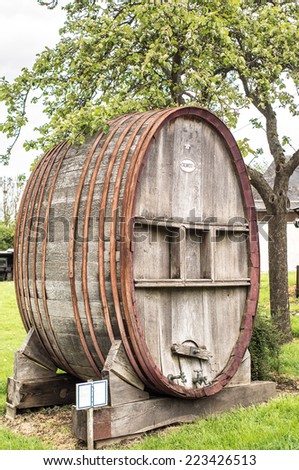 Wooden Calvados barrels with iron rings, with peasant\'s house on the background in Cambremer, Normandy, Franc