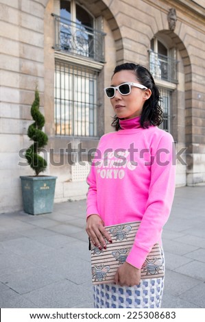 PARIS - FEBRUARY 26, 2014: Stylish Asian woman with sunglasses, pink vestment at the Place Vendome. Paris Fashion Week: Ready to Wear 2014/2015 is held in Paris from February 25 to March 5, 2014.