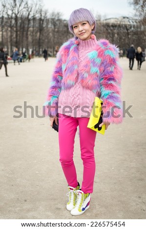 PARIS - MARCH 5, 2013: Stylish Asian woman with pink hair and colorful coat in the Tuileries Garden. Paris is one of the capitals of fashion in the world.