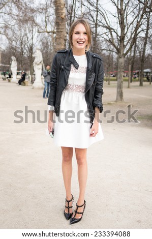 PARIS - MARS 5, 2013: Stylish European woman with white skirt and black leather jacket in the Tuileries Garden. Paris Fashion Week: Ready to Wear 2013/2014 is held from February 26 to March 6, 2013.