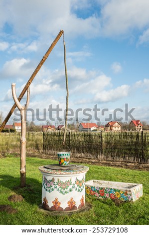 ZALIPIE,POLAND - JANUARY 4, 2015:A bucket over a well in the Colorful Village - heritage park where all buildings and objects are decorated with traditional floral motif. Open-air museum.