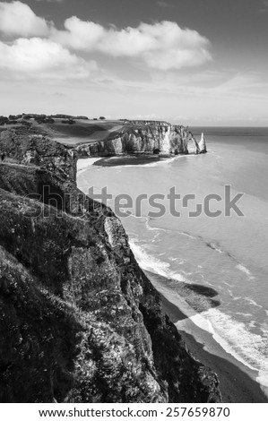 Black and white landscape: Etretat Aval cliff, rocks and natural arch landmark and blue ocean. Aerial view. Normandy, France, Europe.