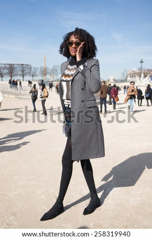 PARIS, FRANCE - MARCH 6, 2015: Stylish black woman with black leaather in the Tuileries Garden. Paris Fashion Week: Ready to Wear 2015/2016 is held from March 3 to 11, 2015.