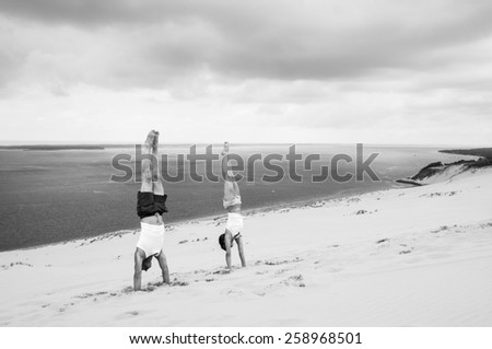 PYLA SUR MER, FRANCE - JULY 5, 2014: A woman and a man stand upside down on the dune of pilat, which is the highest sand dune in Europe.