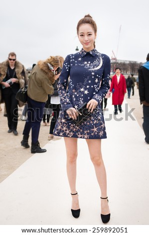 PARIS, FRANCE - MARCH 10, 2015: Stylish Asian woman with moon and star pattern skirt in the Tuileries Garden. Paris Fashion Week: Ready to Wear 2015/2016 is held from March 3 to 11, 2015.