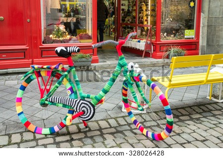 AACHEN, GERMANY - DECEMBER 6, 2014: A bicycle covered by colorful pullovers in front of a shop. Aachen is a city with population of 260,000 in North Rhine-Westphalia.
