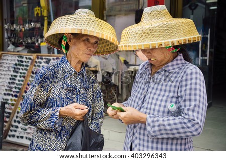 YACHENG, HAINAN, CHINA - SEPTEMBER 8, 2015: Women preparing and chewing betel nuts. The habit of chewing betel nut is prevailed in this southern island of China.