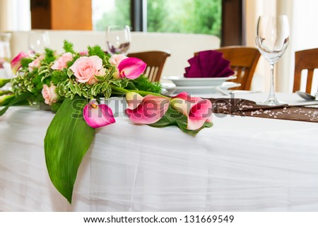 Detail of wedding table set with pink kalas and peach roses