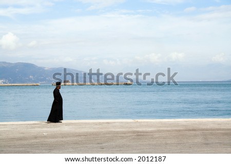 An Orthodox priest standing on the ferry dock on Corfu island, Greece