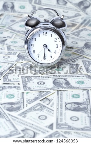 Alarm clock on US paper currency, close up