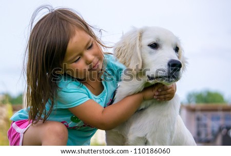 Toddler hugging Golden Retriever puppy