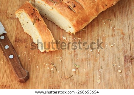 Loaf of white wheat homemade bread crumbs wooden background