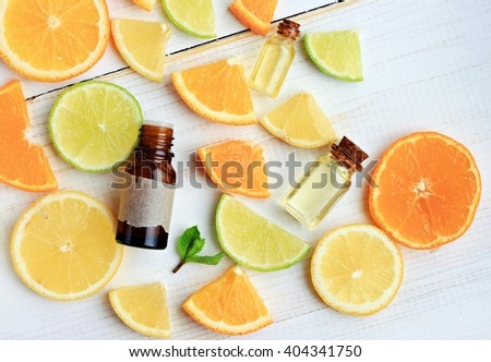 Citrus essential oil. Various citrus fruit and aroma bottles. Orange, lime, lemon slices. Top view.