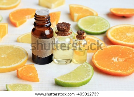 Essential oils set, orange, lime, lemon. Aroma bottles, citrus fruit slices.