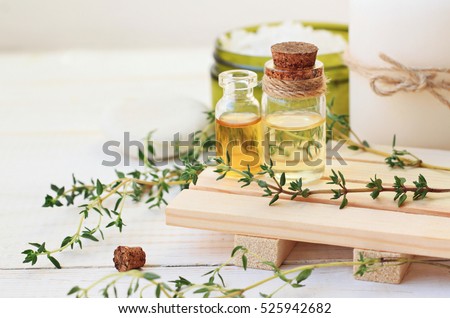 Thyme essential oil. Bottles with extract, fresh green plant leaves. Aromatherapy treatment.