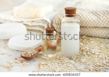 Homemade skincare cosmetic. Rice water and oat flakes facial cleanser. Bottle of cereal milk, grains, towels and cotton pads