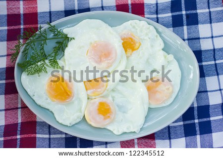Fried eggs on a ceramic plate top view