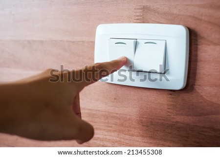 Turning off  on wooden wall-mounted light switch - energy saving concept