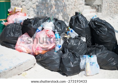 KOH LIPE, THAILAND - February 23, 2015: garbage in black plastic bags on beach in the southern  island of Thailand - environmental pollution concept