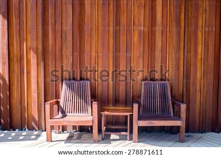 two wooden chairs with wood background