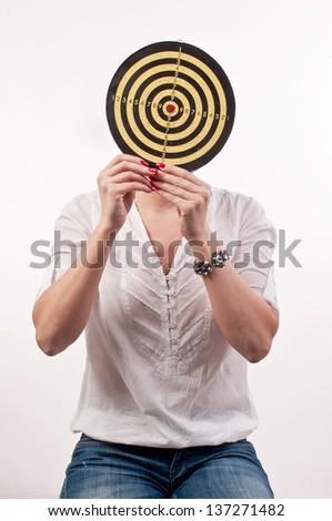 Young woman with dartboard in front of face, Bull\'s Eye