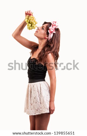 Beautiful young woman let her head back to eating a bunch of grapes