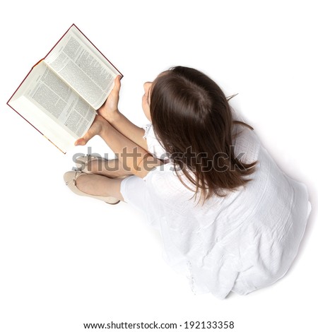 Woman sitting on the floor and reading a Bible from above Woman sitting on the floor and reading a Bible from above