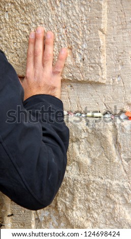 Hand of praying man on the Western Wall  in Jerusalem