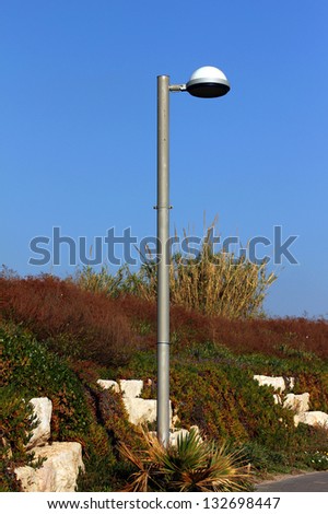 Lighting pole on  promenade by the sea on blue sky background