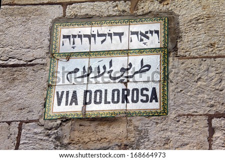 Jerusalem, Israel: street sign on Via Dolorosa, the holy path Jesus walked on his final day - sign in Hebrew, Arabic and Latin, tile on stone wall