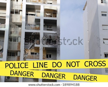 Police line do not cross sign tape on damaged by explosion  building background