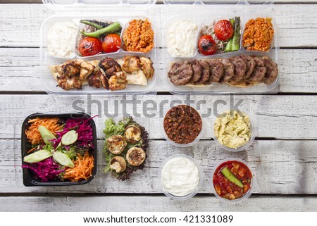 A take away plate with gyros meat and salad on top view white wood background