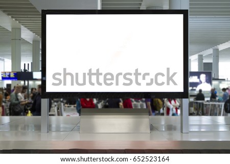 Big Horizontal Blank White Billboard Screen in airport. People are waiting luggage and talking at background. Selective Focus.