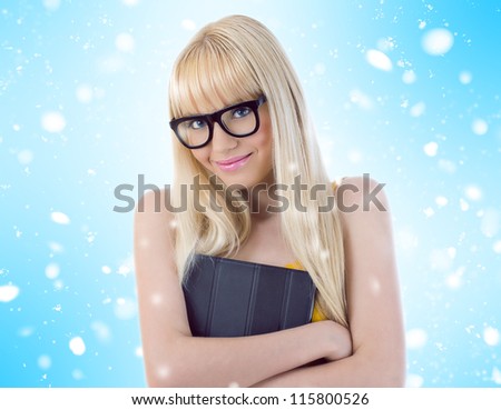 Young girl in glasses hugging her book tightly. Snowflakes