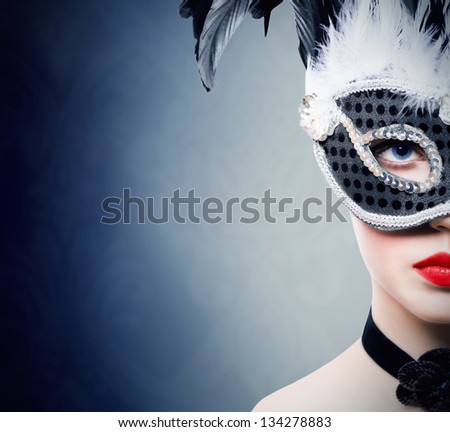 Beautiful young woman in black carnival mask