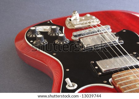 Red electric guitar on gray back ground