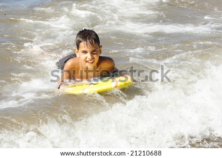 Boy with the surfing board reaching the coast