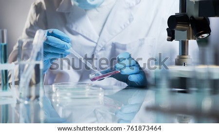 Lab technician checking material by creating chemical reaction with reagents