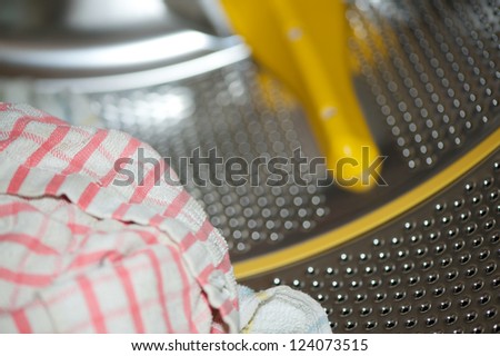 A dirty towel inside a washing machine with the drum defocused