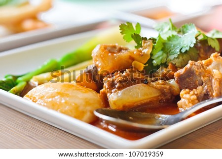 Pork rib roast with a sweet sauce on a white plate.