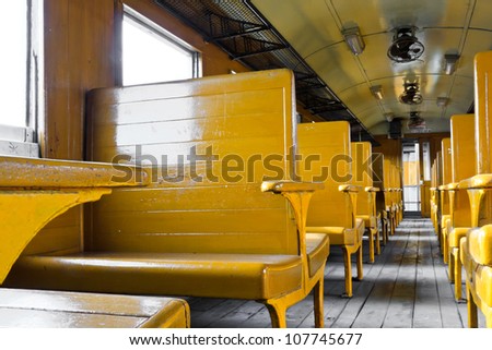 Train seats yellow in the old train.